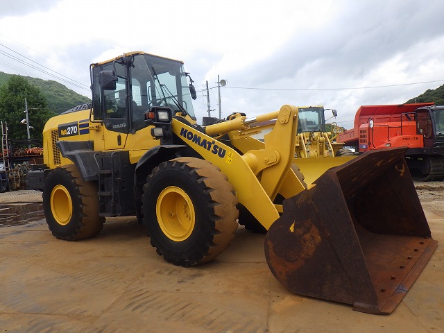 Used Komatsu WA270 wheel loader with bucket lowered at a yard in Japan